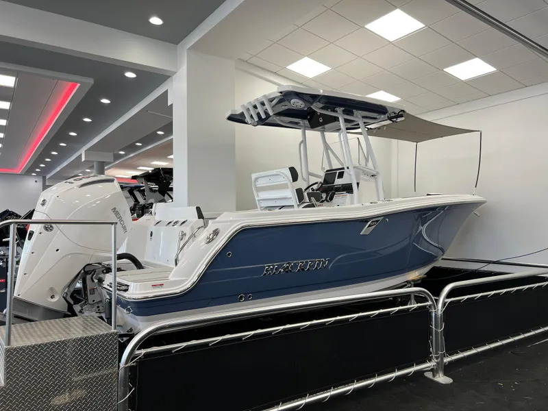 Slide: The Image of 2025 Blackfin 222CC boat displayed indoors, featuring sleek design and modern amenities. - 1