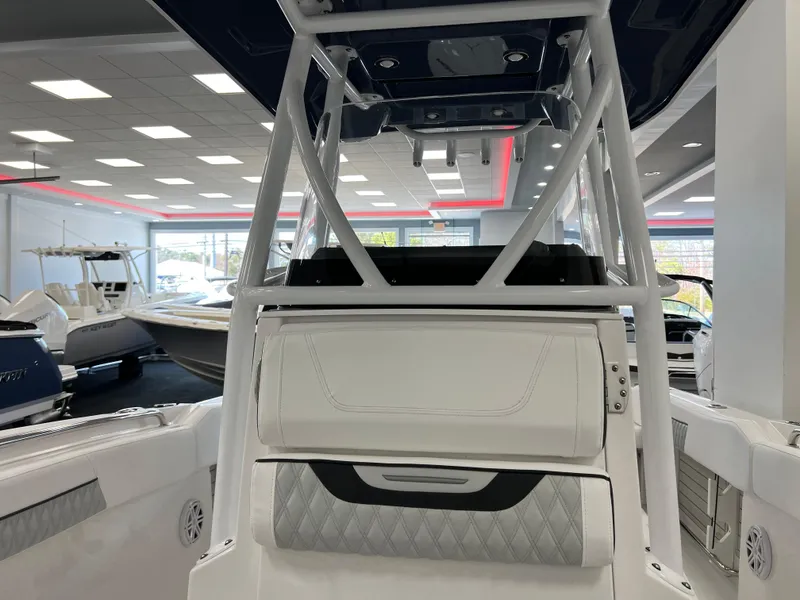 Slide: The Image of 2025 Blackfin 222CC boat interior with modern seating and sleek design in showroom. - 18
