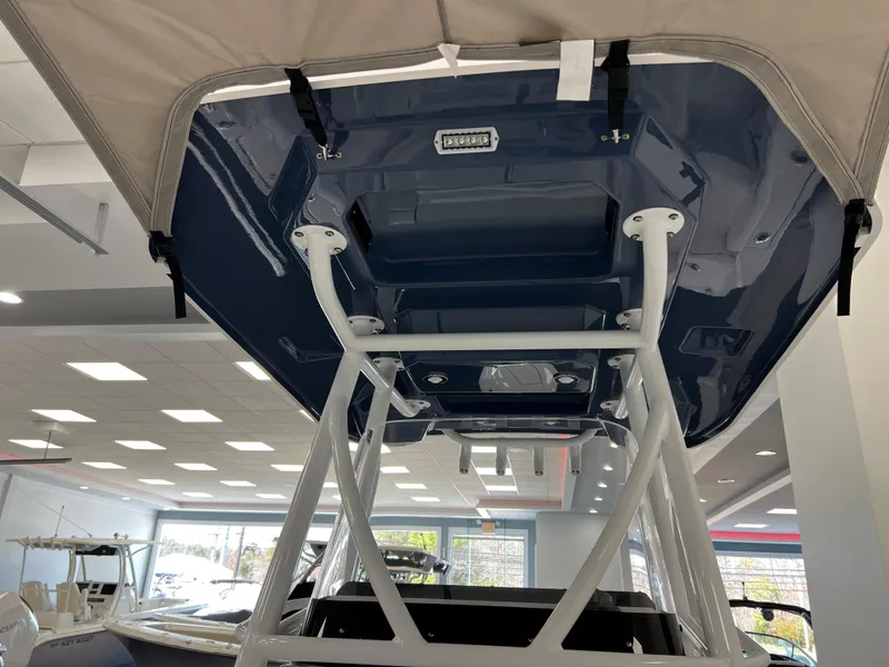 Slide: The Image of 2025 Blackfin 222CC boat interior, showcasing the T-top structure in a showroom setting. - 19