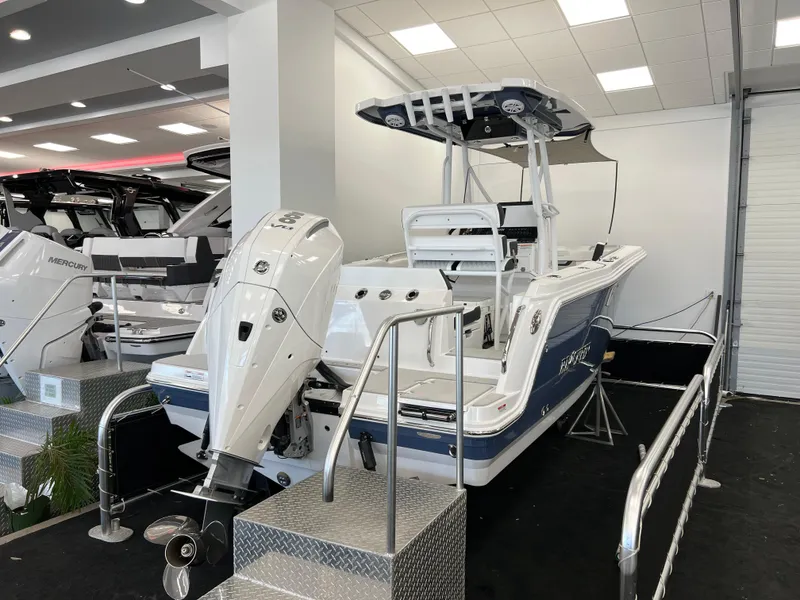 Slide: The Image of 2025 Blackfin 222CC boat displayed indoors with powerful outboard motor. - 2