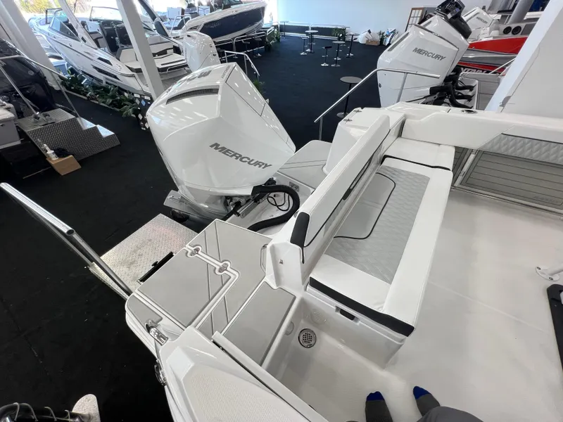 Slide: The Image of 2025 Blackfin 222CC boat with Mercury engines displayed in a showroom. - 24