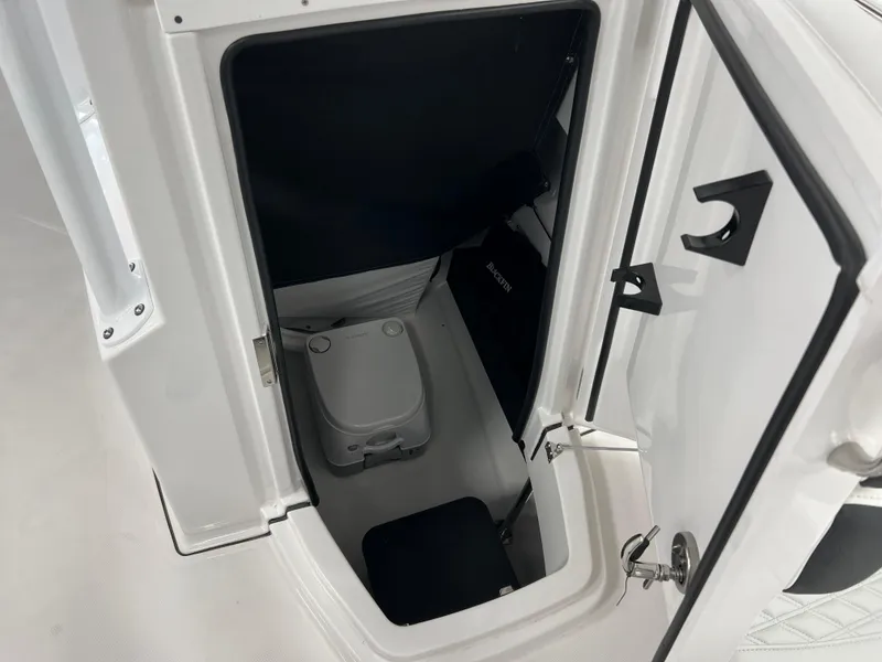 Slide: The Image of 2025 Blackfin 222CC boat interior storage compartment with portable toilet. - 27