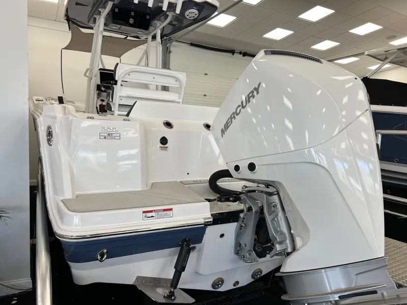 Slide: The Image of 2025 Blackfin 222CC boat with Mercury outboard engine in showroom setting. - 4