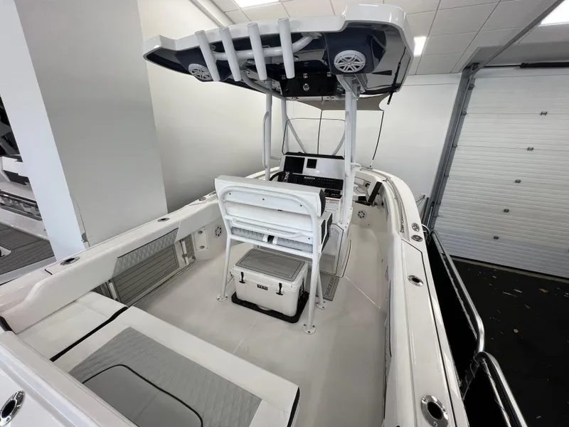 Slide: The Image of 2025 Blackfin 222CC boat interior with seating, console, and T-top in a showroom. - 7