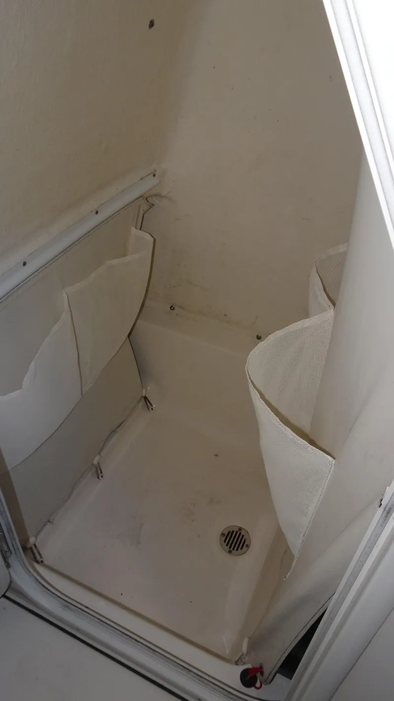 Slide: The Image of 2015 Key West 219 FS boat storage compartment with drain and side pockets. - 11