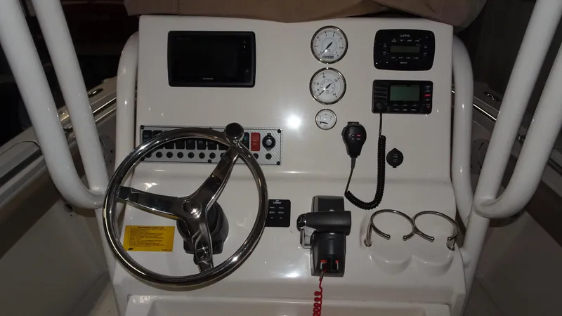 Slide: The Image of 2015 Key West 219 FS boat dashboard with steering wheel and control panel. - 12