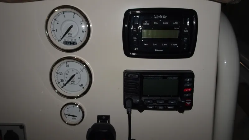 Slide: The Image of Dashboard of a 2015 Key West 219 FS boat with gauges and radio controls. - 13