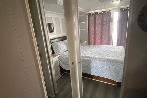 Slide: The Image of Bedroom interior of 1985 Sumerset 60 X 14 houseboat with bed, curtains, and modern decor. - 6
