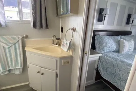 Slide: The Image of 1985 Sumerset houseboat interior with bathroom sink and cozy bedroom. - 7