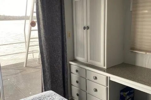 Slide: The Image of 1985 Sumerset 60 X 14 houseboat interior with cabinets and water view. - 8