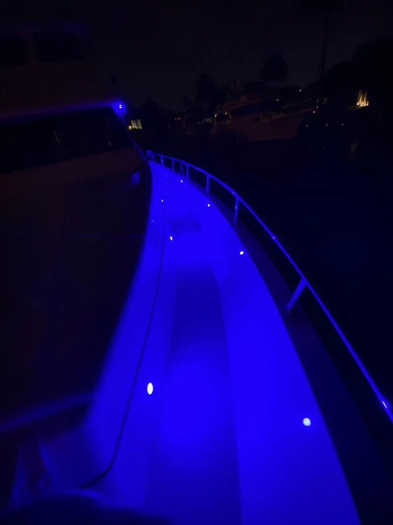 Slide: The Image of 2003 Hargrave Sky Lounge yacht with vibrant blue deck lighting at night. - 47