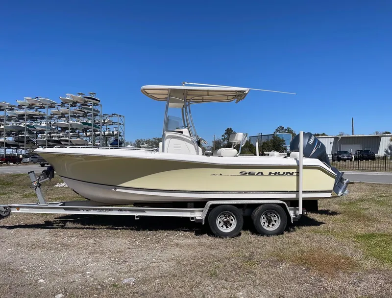 Slide: The Image of 2007 Sea Hunt Triton 207 boat on trailer, parked outdoors under clear blue sky. - 0