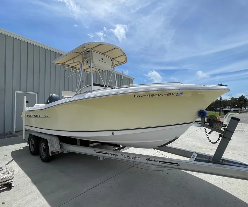 Slide: The Image of 2007 Sea Hunt Triton 207 boat on trailer, parked outdoors under a clear blue sky. - 1