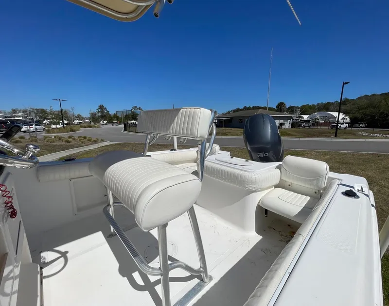 Slide: The Image of 2007 Sea Hunt Triton 207 boat interior with seating and motor, under clear blue sky. - 11