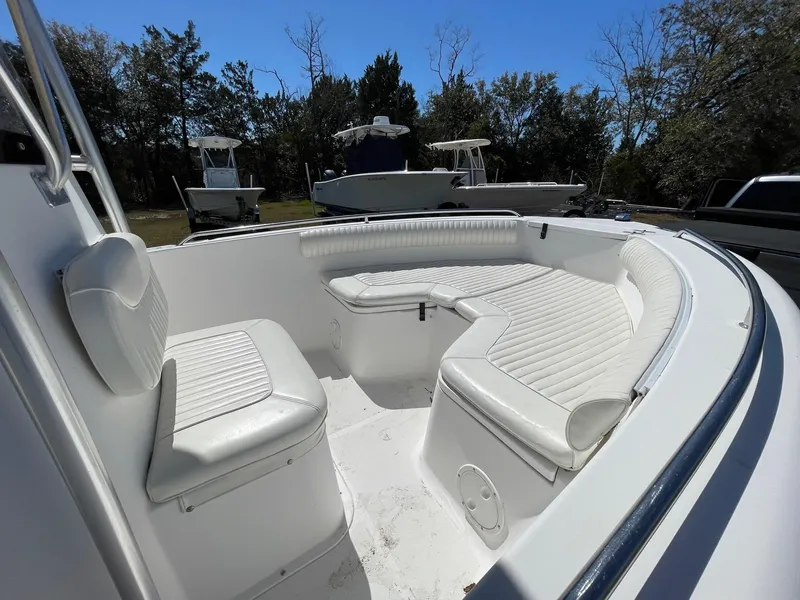 Slide: The Image of 2007 Sea Hunt Triton 207 boat with white cushioned seating in a sunny outdoor setting. - 12