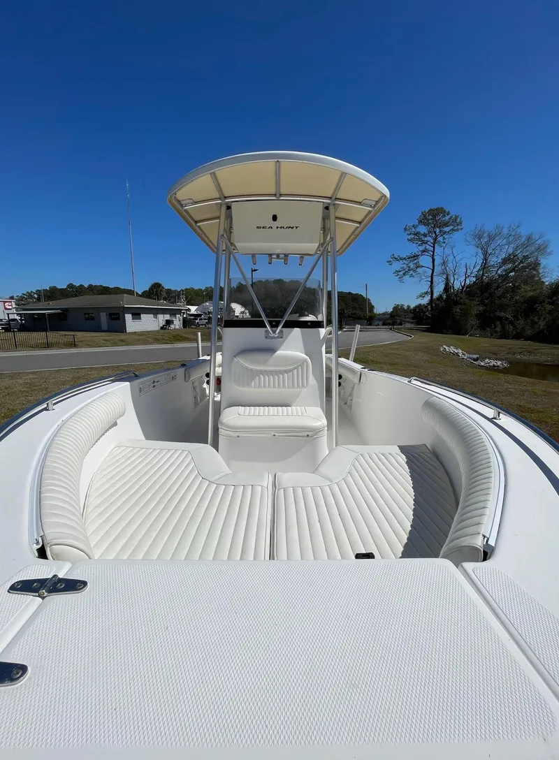Slide: The Image of 2007 Sea Hunt Triton 207 boat with white seating and T-top under clear blue sky. - 16