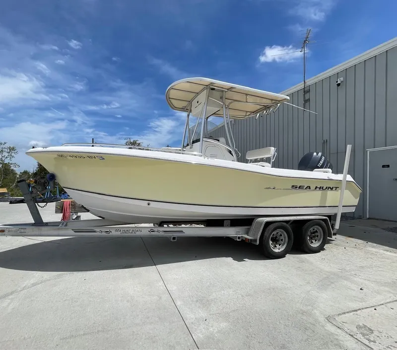Slide: The Image of 2007 Sea Hunt Triton 207 boat on trailer, parked outdoors under blue sky. - 2