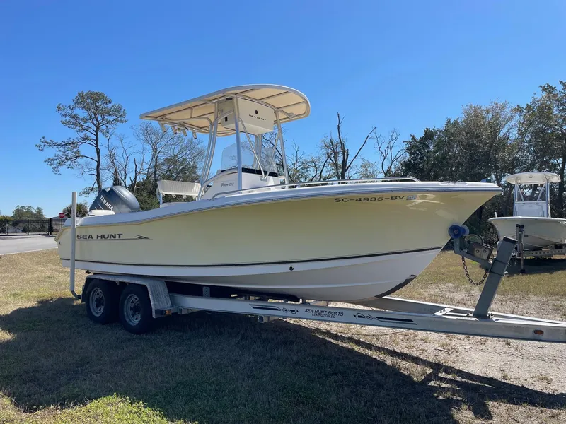 Slide: The Image of 2007 Sea Hunt Triton 207 boat on trailer, parked on grass under clear blue sky. - 3