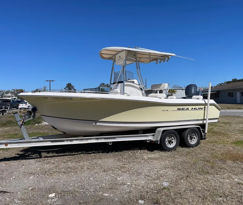 Slide: The Image of 2007 Sea Hunt Triton 207 boat on trailer, parked outdoors under clear blue sky. - 6