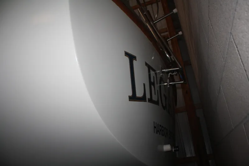 Slide: The Image of 1978 Bombay Clipper Sloop sailboat in storage, showing partial name and hull detail. - 21