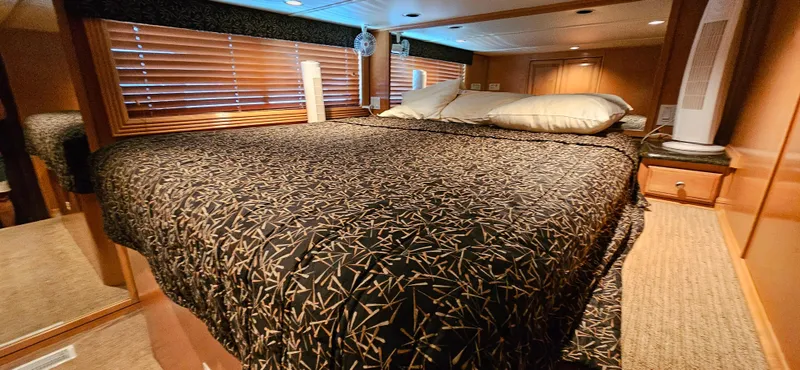 Slide: The Image of Cozy bedroom interior of 2000 Sumerset Houseboat 21' x 75', featuring a patterned bedspread. - 10