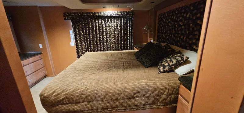 Slide: The Image of Cozy bedroom in 2000 Sumerset Houseboat, featuring a large bed and patterned curtains. - 11