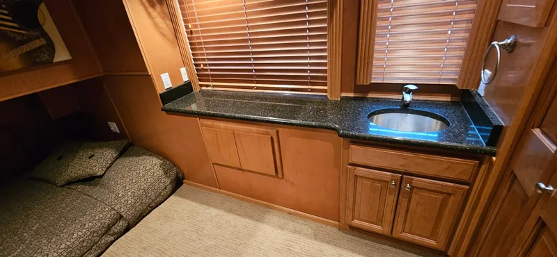 Slide: The Image of Interior of 2000 Sumerset Houseboat with bed, countertop, sink, and wooden cabinetry. - 14