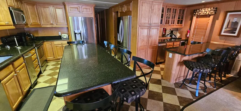 Slide: The Image of Luxurious kitchen interior of 2000 Sumerset Houseboat, featuring granite countertops and wooden cabinetry. - 6