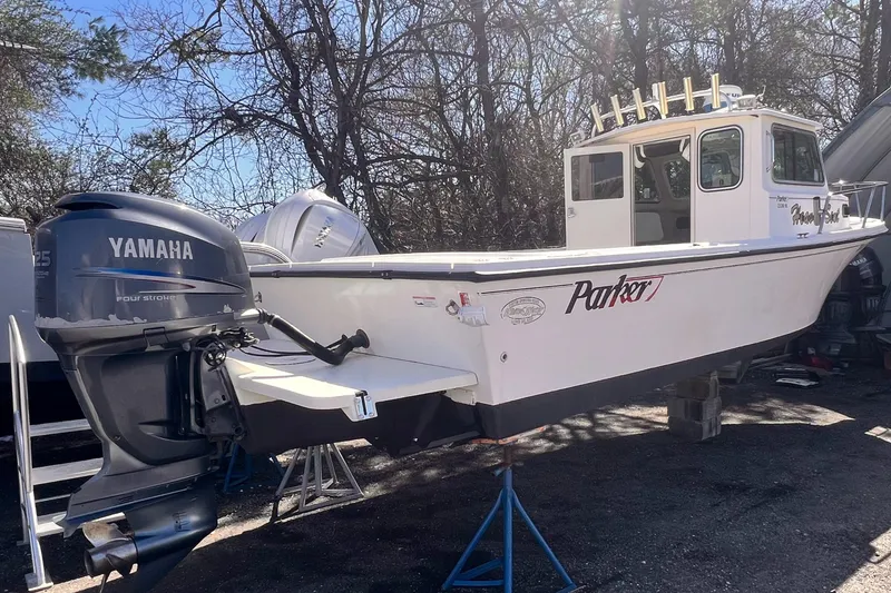 Slide: The Image of 2006 Parker 2320 SL Sport Cabin boat with Yamaha outboard motor, parked outdoors. - 1