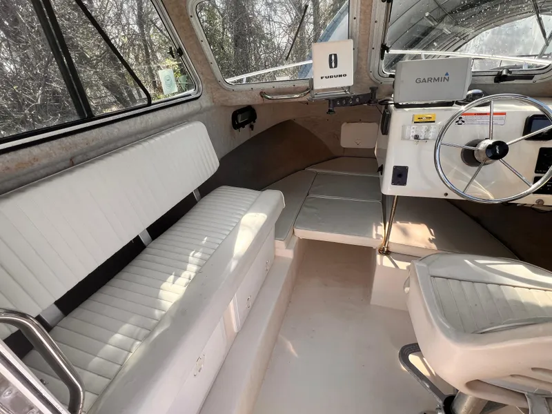 Slide: The Image of Interior of a 2006 Parker 2320 SL Sport Cabin boat with white seating and steering console. - 3