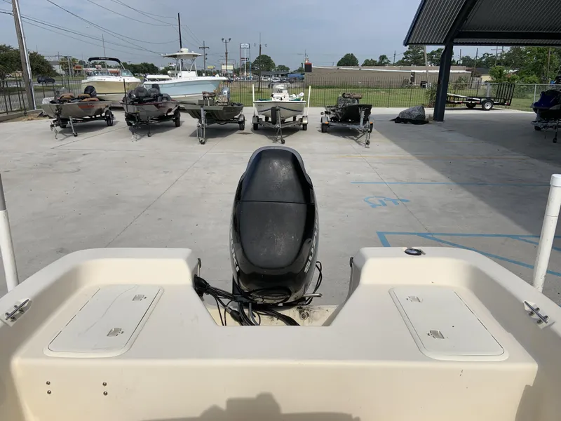 Slide: The Image of 2003 Sea Chaser 190 Bay boat with outboard motor in a parking area. - 12