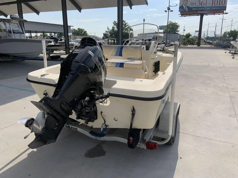 Slide: The Image of 2003 Sea Chaser 190 Bay boat on trailer with outboard motor in a marina. - 17