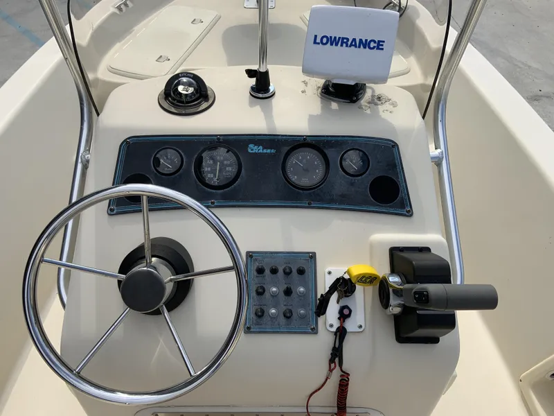 Slide: The Image of 2003 Sea Chaser 190 Bay boat dashboard with steering wheel and navigation equipment. - 23