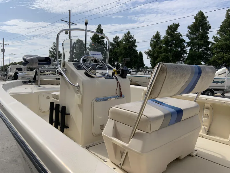 Slide: The Image of 2003 Sea Chaser 190 Bay boat interior with steering console and seating, under a clear sky. - 25