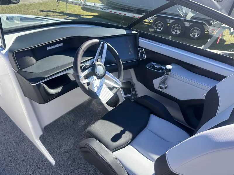 Slide: The Image of 2025 MasterCraft X24 boat interior with modern steering wheel and dashboard. - 11