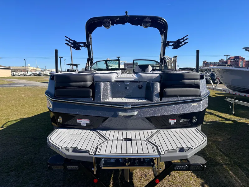 Slide: The Image of 2025 MasterCraft X24 boat, rear view, on display outdoors under clear blue sky. - 3