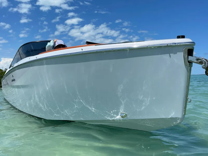 Slide: The Image of 2022 Cranchi 26 Rider boat on clear water under a blue sky. - 1
