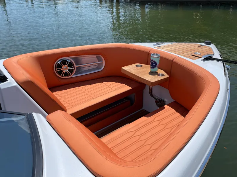 Slide: The Image of 2022 Cranchi 26 Rider boat with orange seating and a drink holder on a sunny day. - 11
