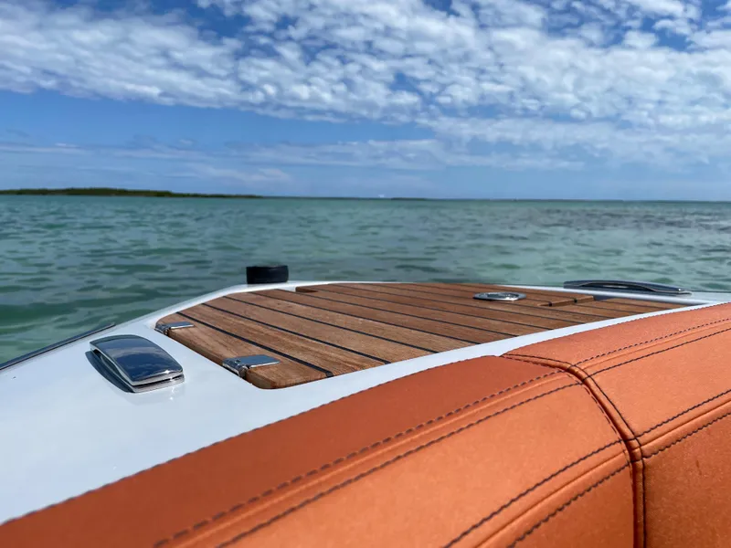 Slide: The Image of 2022 Cranchi 26 Rider boat on calm water under a partly cloudy sky. - 12