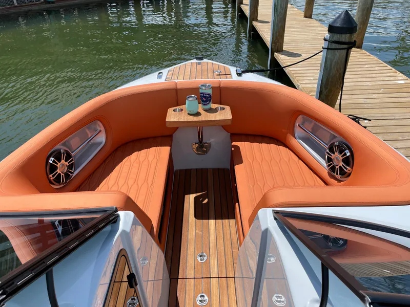 Slide: The Image of 2022 Cranchi 26 Rider boat with orange seating and wooden deck by the dock. - 15