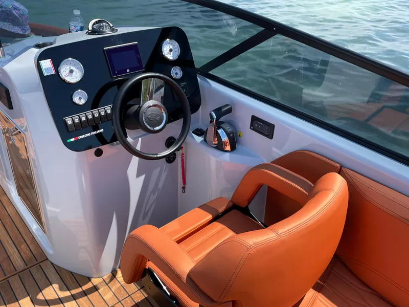 Slide: The Image of 2022 Cranchi 26 Rider boat cockpit with modern controls and leather seat. - 18