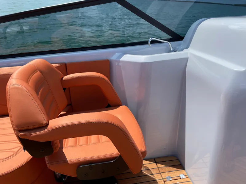 Slide: The Image of Orange seat on 2022 Cranchi 26 Rider boat, with wooden deck and water view. - 20