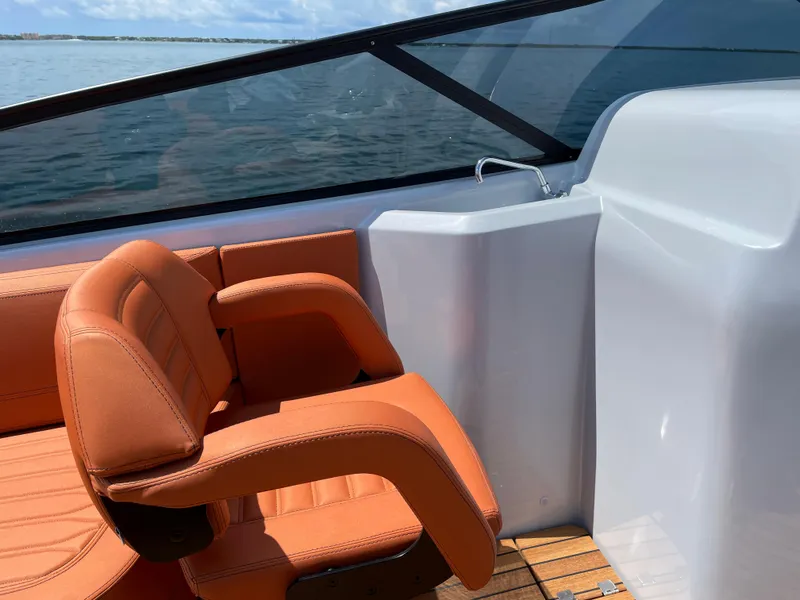 Slide: The Image of 2022 Cranchi 26 Rider boat interior with orange seating and sleek design. - 21