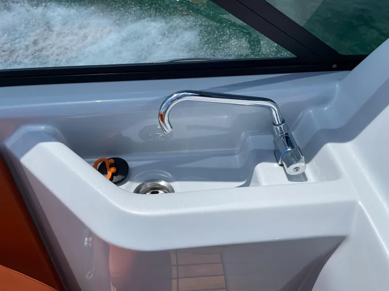 Slide: The Image of Cranchi 26 Rider 2022 boat sink with chrome faucet and water view. - 22