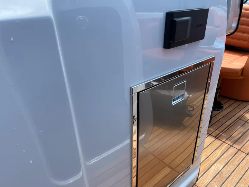 Slide: The Image of 2022 Cranchi 26 Rider boat interior with sleek metal compartment and wooden flooring. - 24