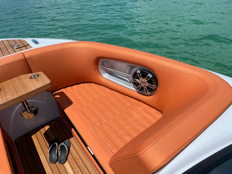 Slide: The Image of Luxurious seating on 2022 Cranchi 26 Rider boat with teak flooring and orange upholstery. - 31