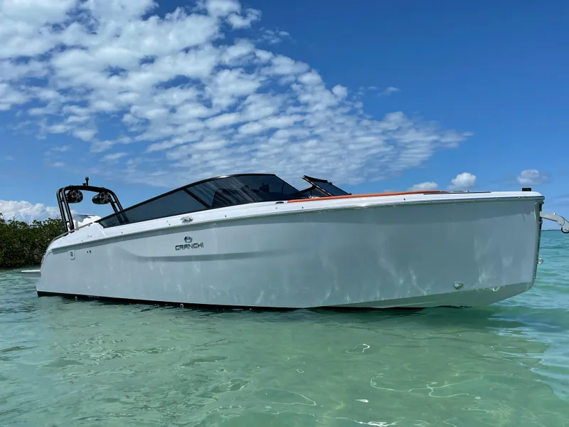 Slide: The Image of 2022 Cranchi 26 Rider boat in clear water under a blue sky. - 6