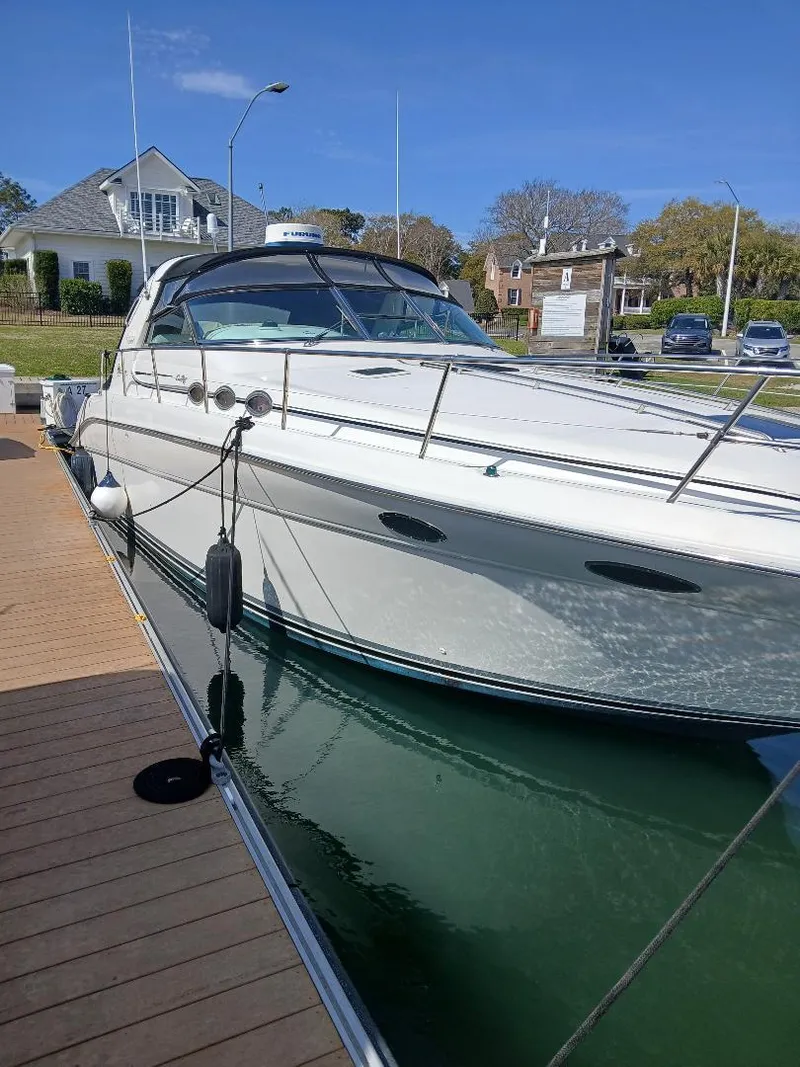 Slide: The Image of 1997 Sea Ray 370 Sundancer docked, showcasing sleek design and white exterior. - 1