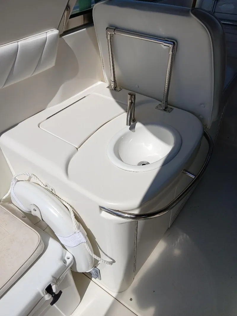 Slide: The Image of 1997 Sea Ray 370 Sundancer boat interior with compact sink and seating area. - 14