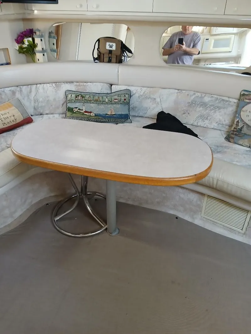 Slide: The Image of 1997 Sea Ray 370 Sundancer interior with curved seating and oval table. - 15